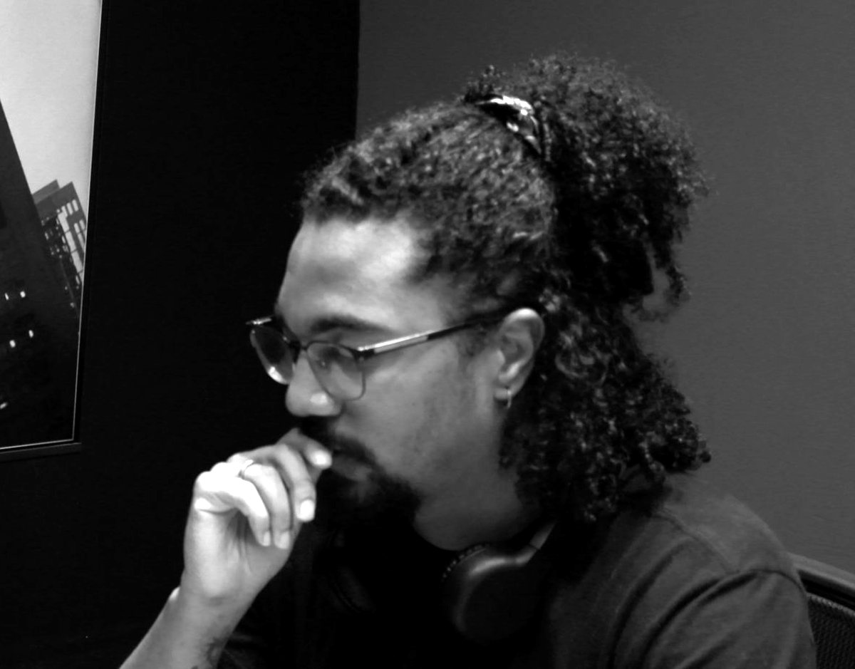 Kayto Beraldo pensativo diante do computador, em preto e branco